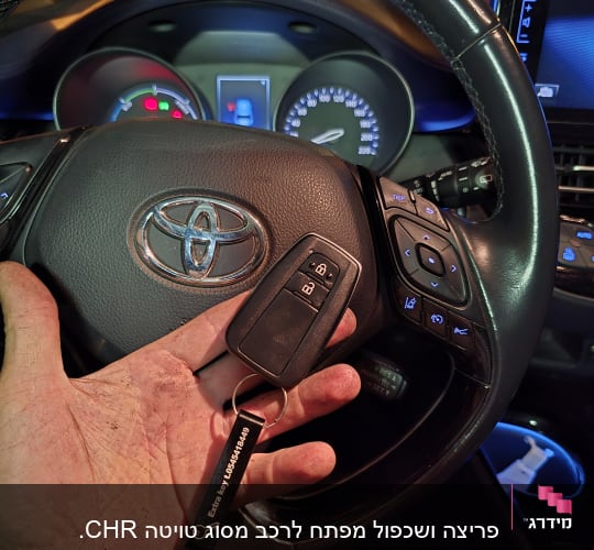 מפתח רכב עם שלט על רקע הגה טויוטה